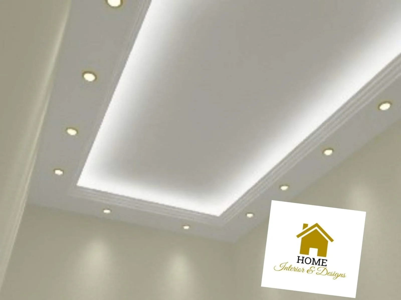 Wide living space under a white tray ceiling with warm pin lights and contractor lettering painted on the wall.