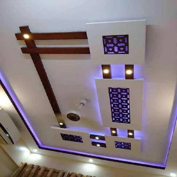 Square ceiling detail lit violet, with perforated panels and dark red beams.