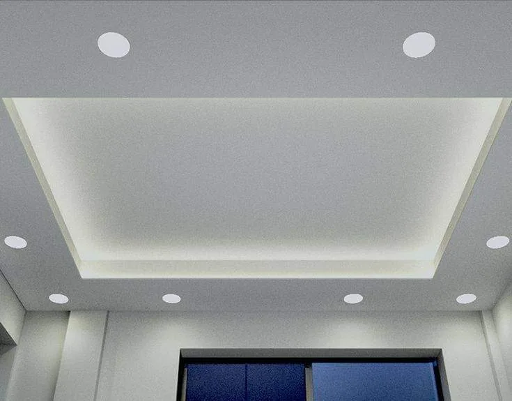Grey tray ceiling with round recessed downlights beside a blue-curtained window.